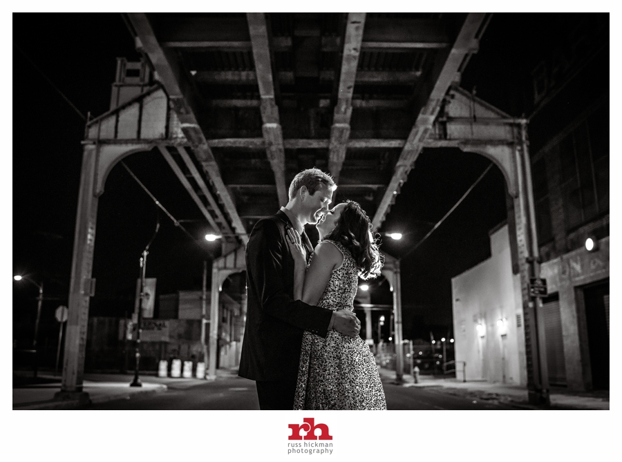 A couple kiss under the El Train at their wedding in Philadelphia.